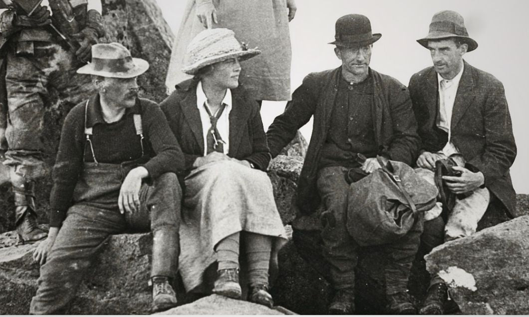 In 1921, Florence Perrin (second from left) rests in a long skirt and straw hat alongside guide Paddy Hartnett on the rocky summit of Mount Pelion West.