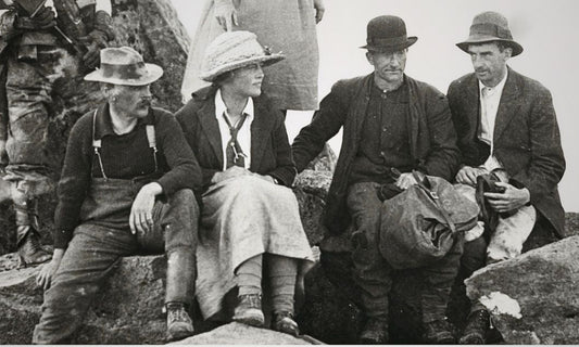 In 1921, Florence Perrin (second from left) rests in a long skirt and straw hat alongside guide Paddy Hartnett on the rocky summit of Mount Pelion West.