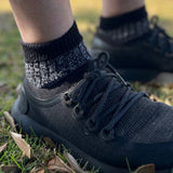 Person wearing black sneakers and 32A-B Coolmax wool blend socks on grass © 'Bluey Merino Tasmania'