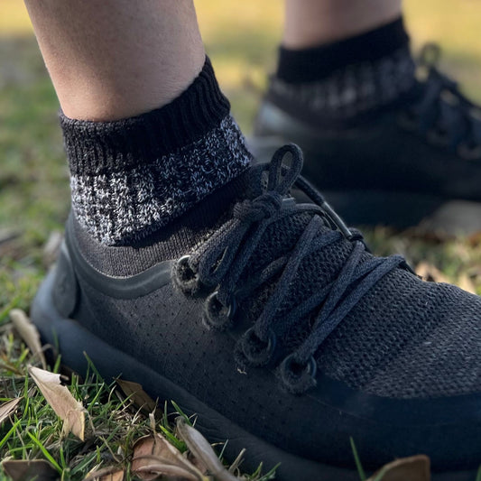Person wearing black sneakers and 32A-B Coolmax wool blend socks on grass © 'Bluey Merino Tasmania'
