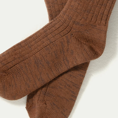 A close-up of a pair of ribbed knit Merino socks in a warm brown Chestnut colour with subtle darker brown flecks, Marl-Marlelaid flat on a white background.