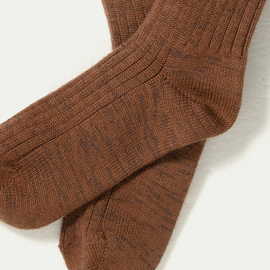 A close-up of a pair of ribbed knit Merino socks in a warm brown Chestnut colour with subtle darker brown flecks, Marl-Marlelaid flat on a white background.