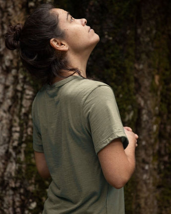 Person in a green Merino cropped t-shirt standing against a giant Tasmanian tree © Bluey Merino Tasmania