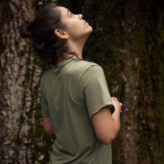 Person in a green Merino cropped t-shirt standing against a giant Tasmanian tree © Bluey Merino Tasmania