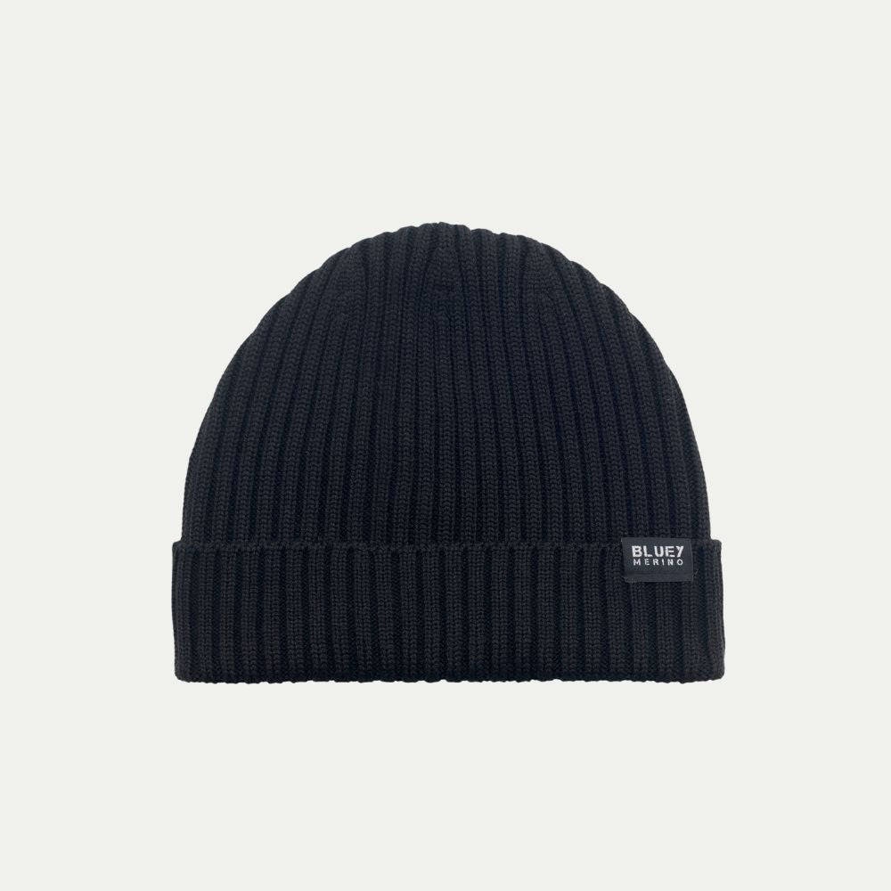 Fisherman knit Merino Black beanie with a brand label on a light grey background © Bluey Merino Tasmania