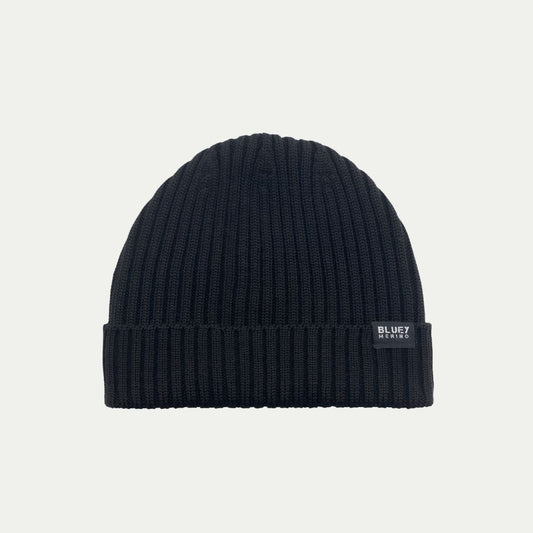 Fisherman knit Merino Black beanie with a brand label on a light grey background © Bluey Merino Tasmania