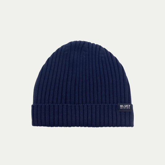 Fisherman knit Navy blue Merino beanie with a brand logo on a light grey background © Bluey merino Tasmania