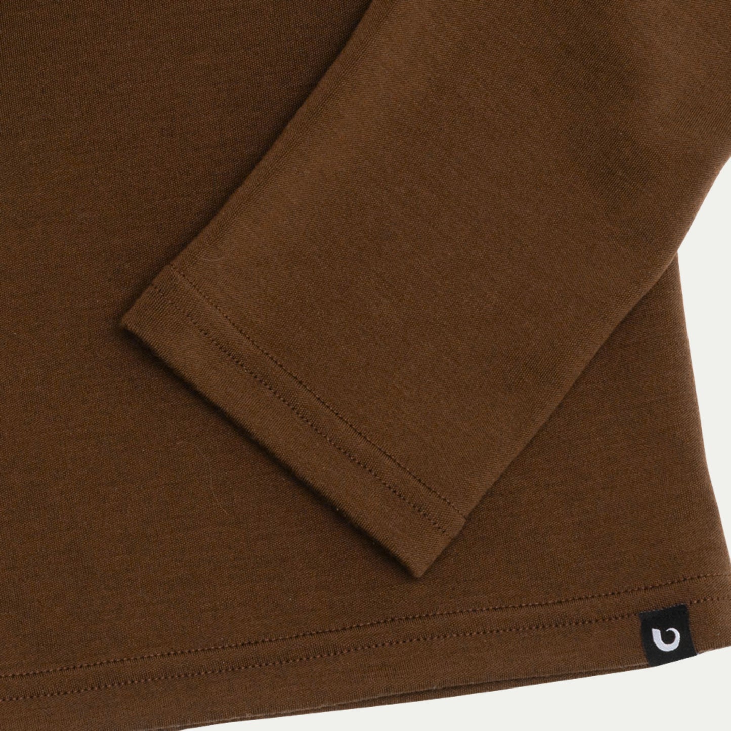 Close up on sleeve cuff. Merino Chestnut Brown long-sleeve henley shirt on a light grey background © Bluey Merino Tasmania