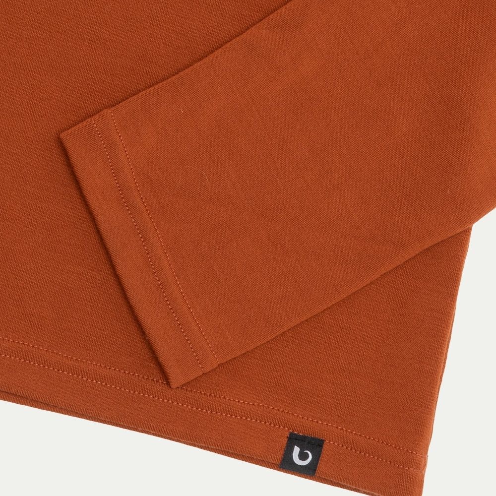 Folded orange fabric with a brand logo on a light gray background