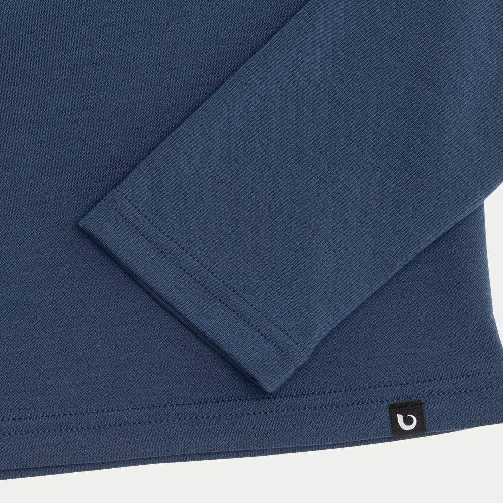 Close-up of a blue long-sleeve shirt with a brand logo on a white background