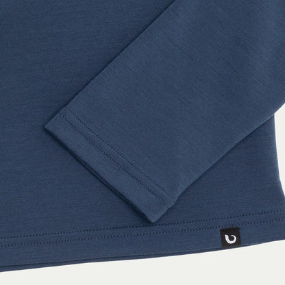 Close-up of a blue long-sleeve shirt with a brand logo on a white background