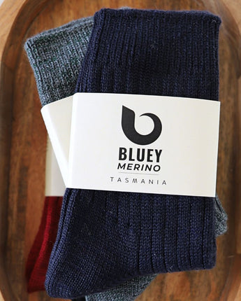 Pair of navy Tasmanian Merino socks with a Bluey Merino label on a wooden tray © Bluey Merino Tasmania