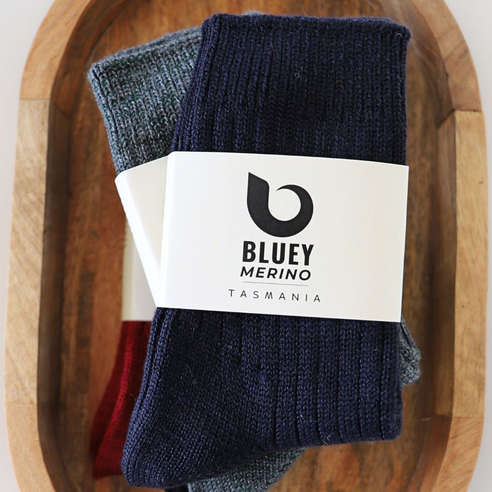 Pair of navy Tasmanian Merino socks with a Bluey Merino label on a wooden tray © Bluey Merino Tasmania
