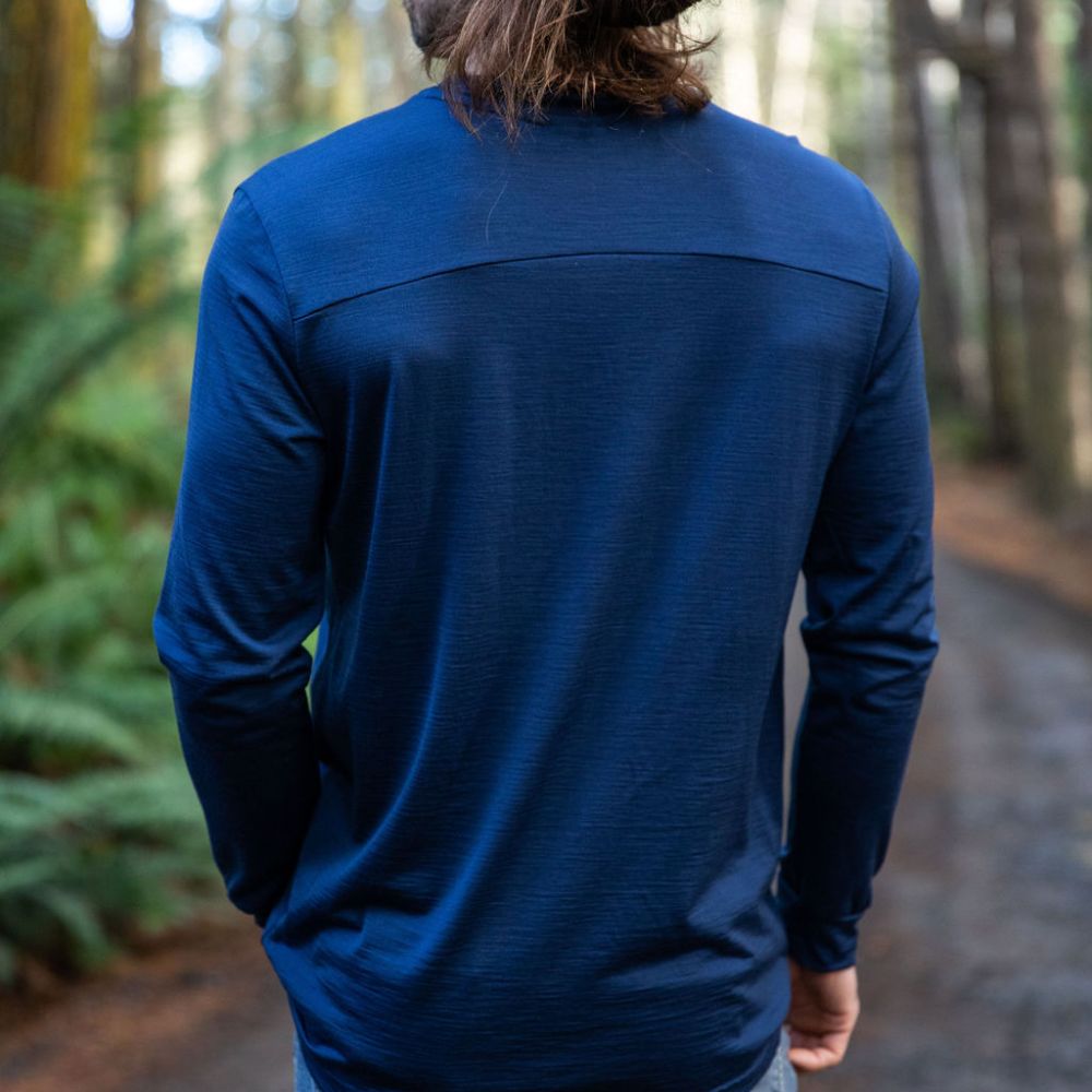 Person wearing a blue Merino long-sleeve shirt in a forest setting - view from the back. © Bluey Merino Tasmania