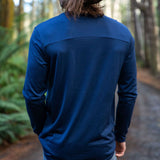 Person wearing a blue Merino long-sleeve shirt in a forest setting - view from the back. © Bluey Merino Tasmania