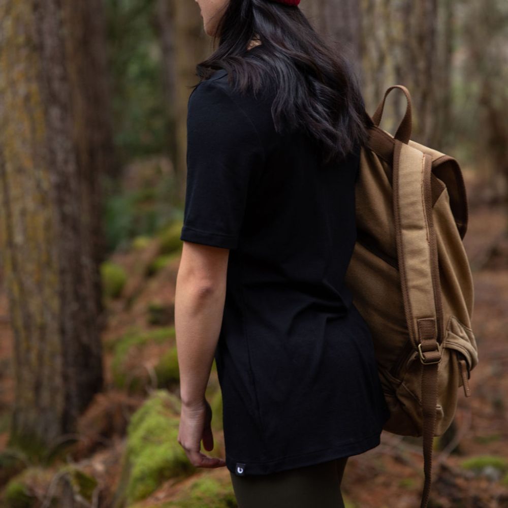 Person wearing a black t-shirt with a blurred natural background in northern Tasmania © Bluey Merino Tasmania