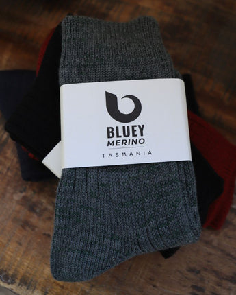 Pair of grey Tasmanian Merino socks with a Bluey Merino label on a wooden tray © Bluey Merino Tasmania